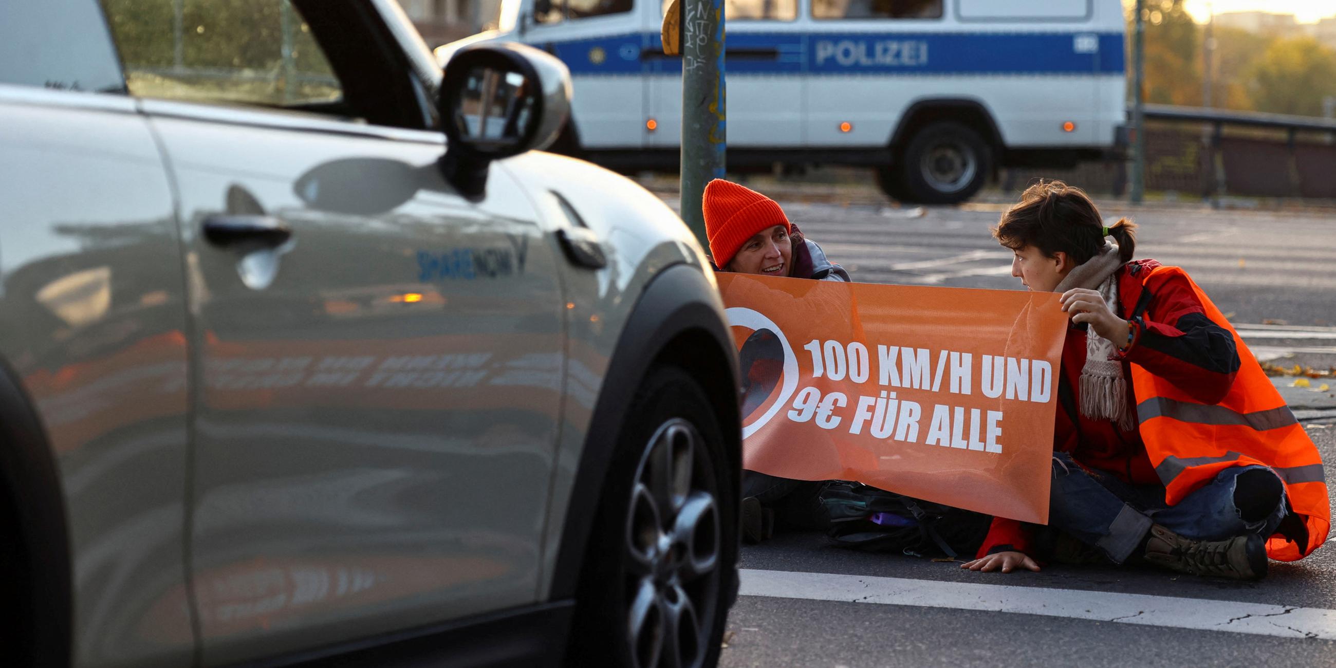 Archiv: Aktivisten der "Letzten Generation" protestieren am 11. 10. 2022 an der Ausfahrt einer Autobahn in Berlin für eine Geschwindigkeitsbegrenzung auf Autobahnen sowie für erschwingliche öffentliche Verkehrsmittel.