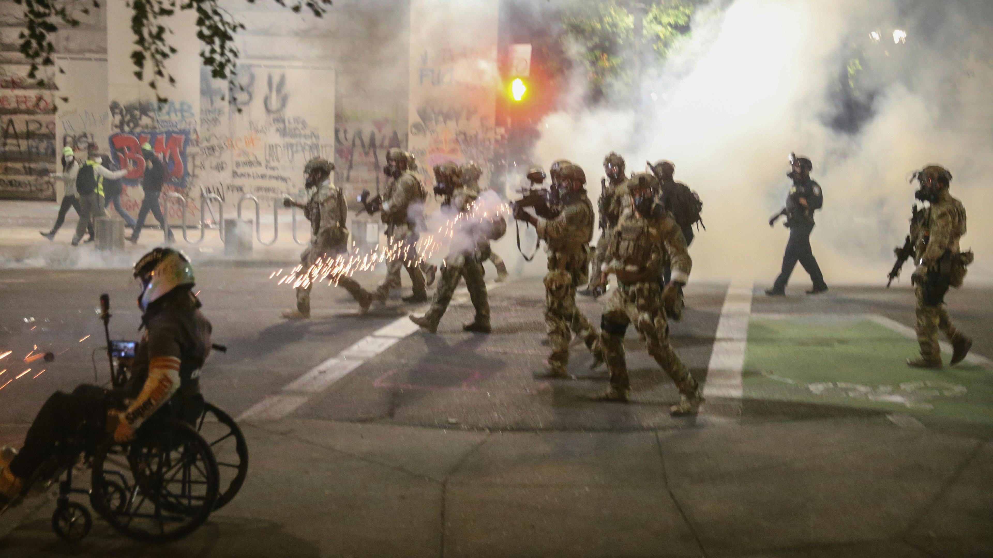 Portland: bewaffnete polizisten feuern bei einer demonstration mit traenengas in richtung der demonstranten.