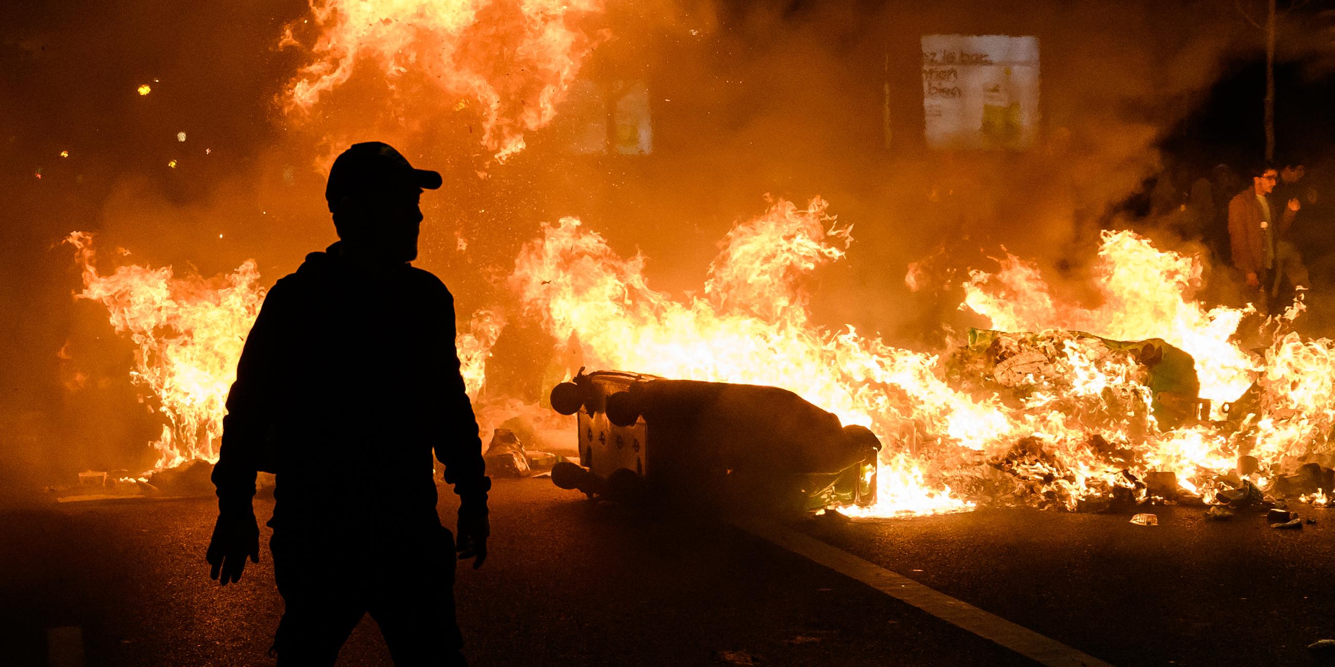 Paris: Demonstranten stehen hinter brennenden Barrikaden.