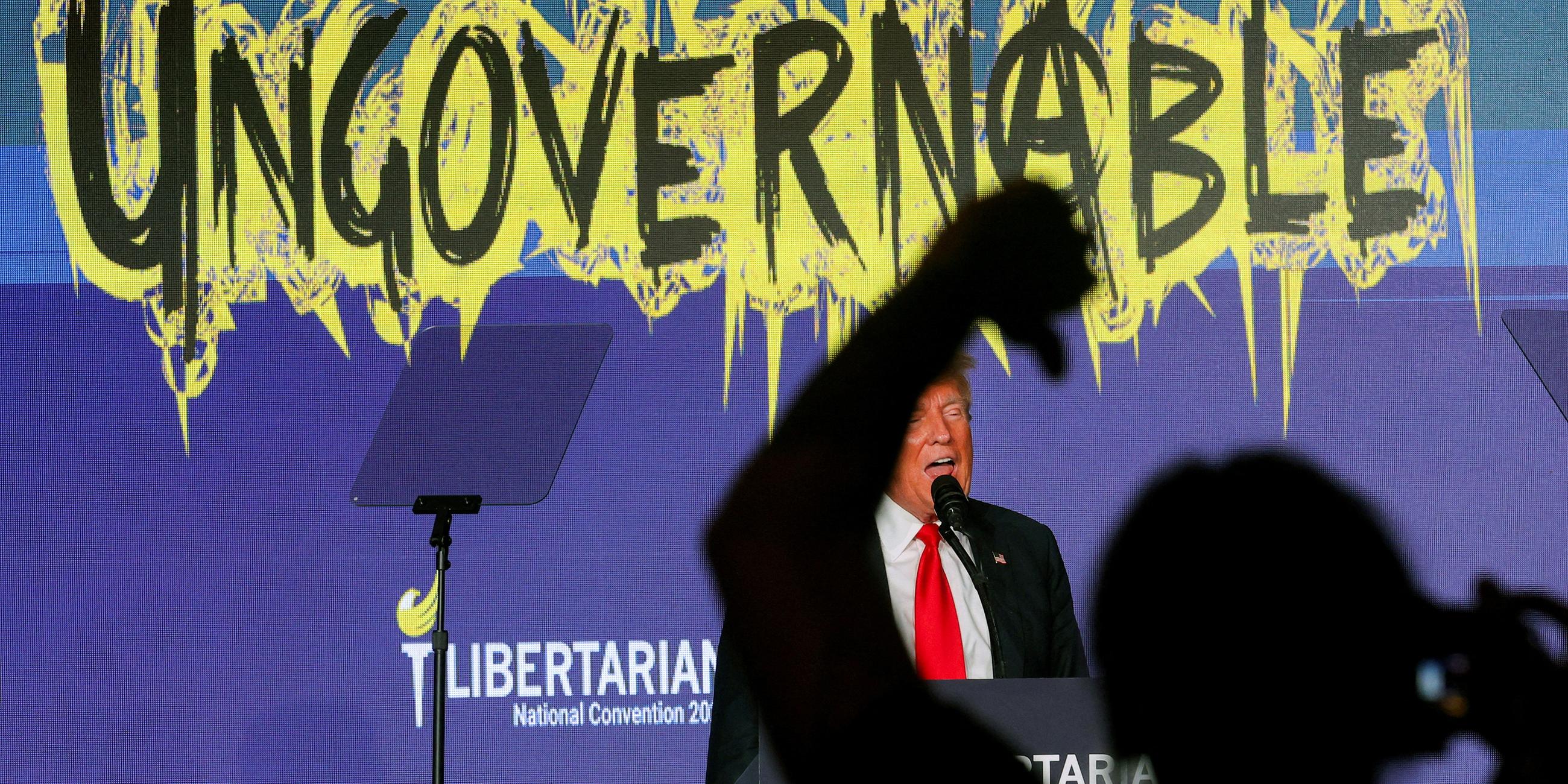 Eine Person in der Menge gestikuliert, während Donald Trump auf dem nationalen Parteitag der Libertarian Party in Washington, USA, spricht.