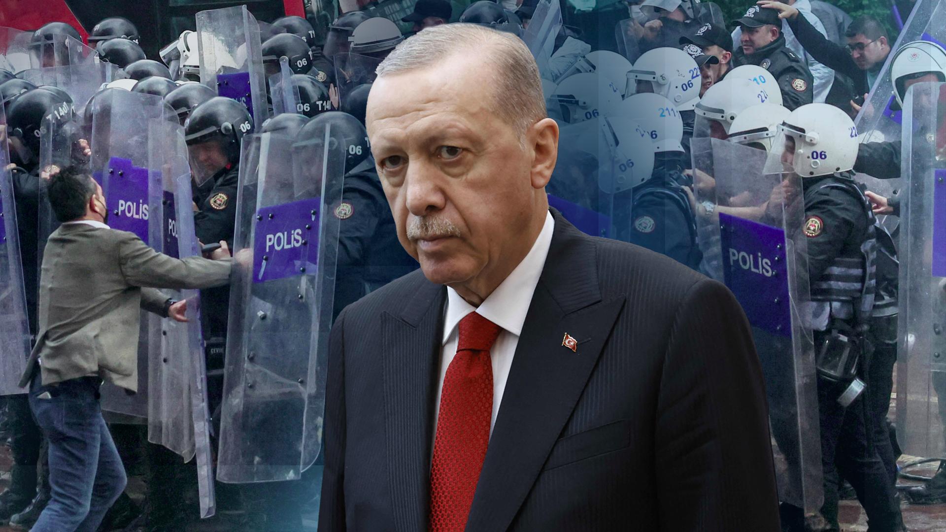 Türkei-Präsident Erdogan im Anzug als Cut-Out zu sehen. Der Hintergrund ist ein Bild von aktuellen Protesten in der Türkei und zeigt wie die Demonstranten auf die Polizei stößt.