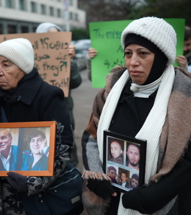 Angehörige protestieren mit Fotos von Opfern des Assad-Regimes