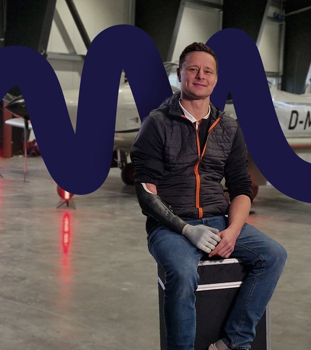 Philipp Barluschke in einem Flugzeughanger, im Hintergrund eine Sportmaschine.