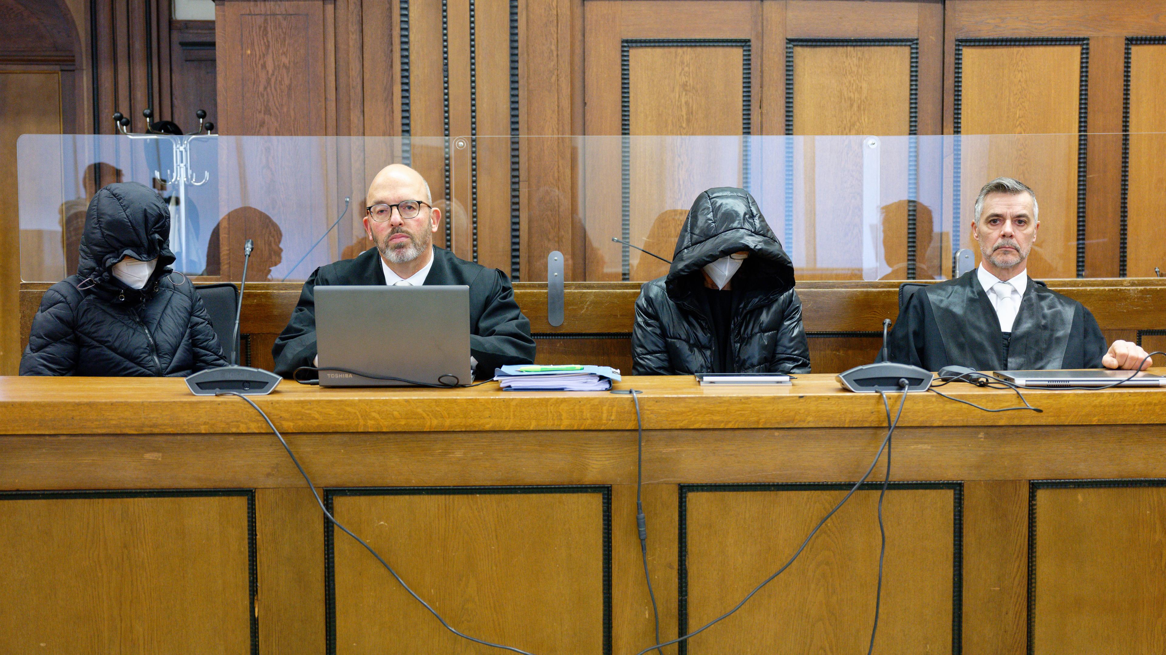 Die beiden Angeklagten und die Rechtsanwälte Lutz Adam (2.v.l) und Marius Kuschka (r) sitzen vor Beginn der Verhandlung im Saal, aufgenommen am 15.02.2024 in Mönchengladbach 