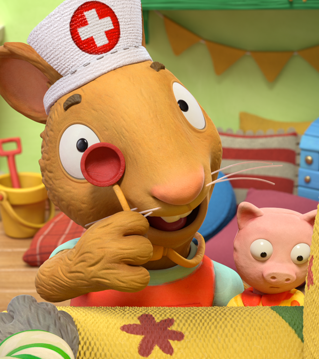 Posy hat ein Krankenschwester-Häubchen auf und hält ein Stethoskop vor ihr rechtes Auge.