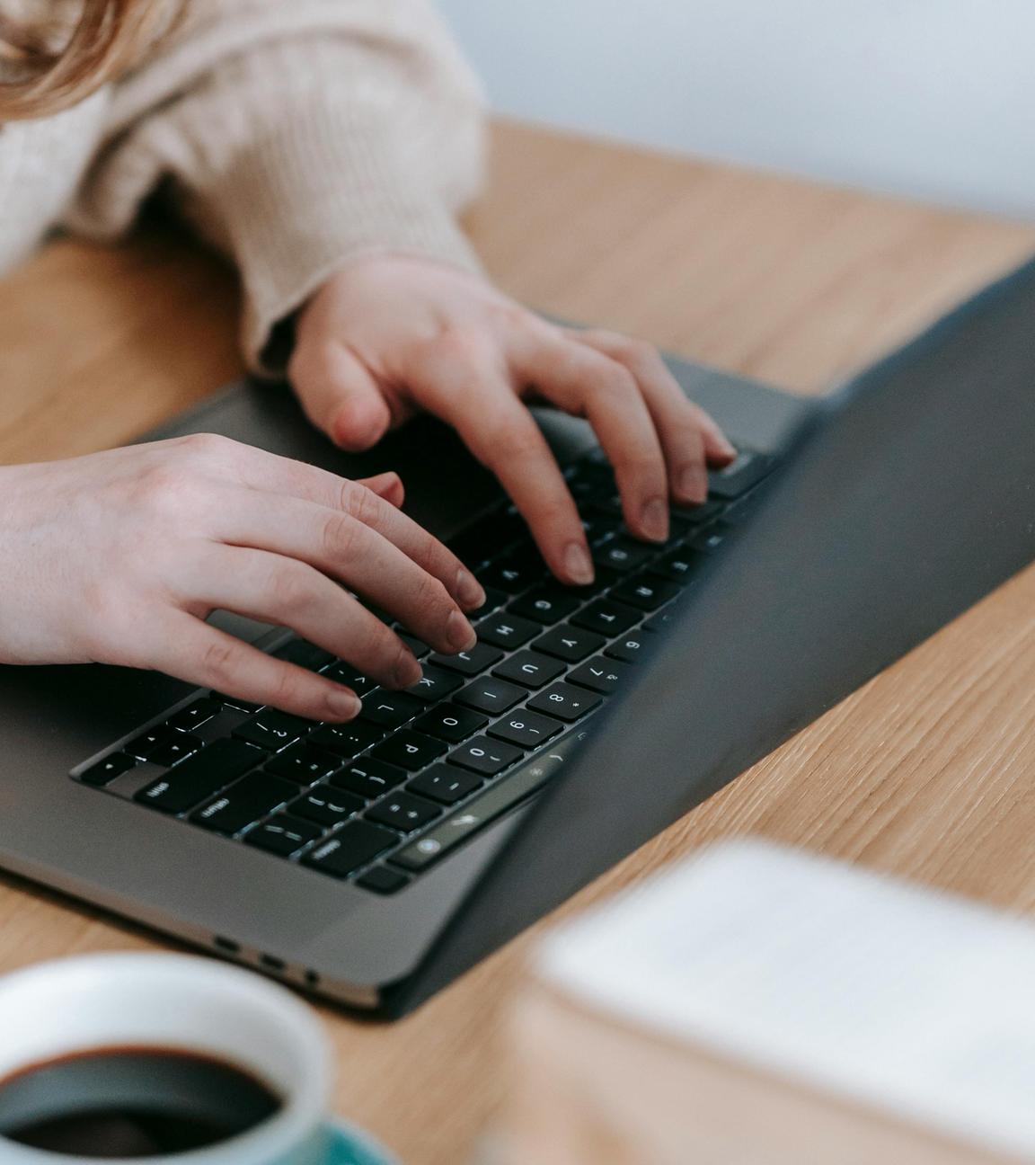 Frauenhände Tippen auf die Tastatur eines Laptops