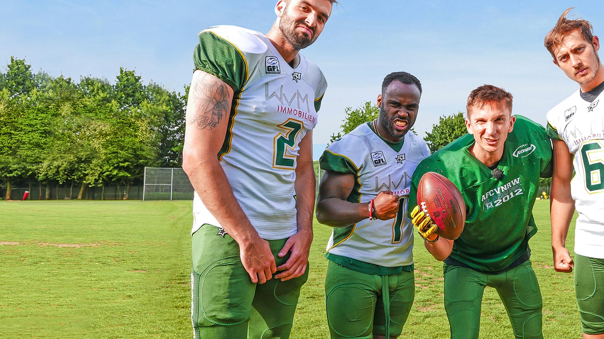 Moderator Eric Mayer in einer Trainingspause zusammen mit drei American Football Spielern der Cologne Crocodiles.