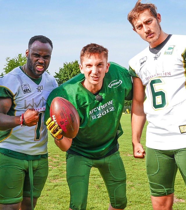 Moderator Eric Mayer in einer Trainingspause zusammen mit drei American Football Spielern der Cologne Crocodiles.