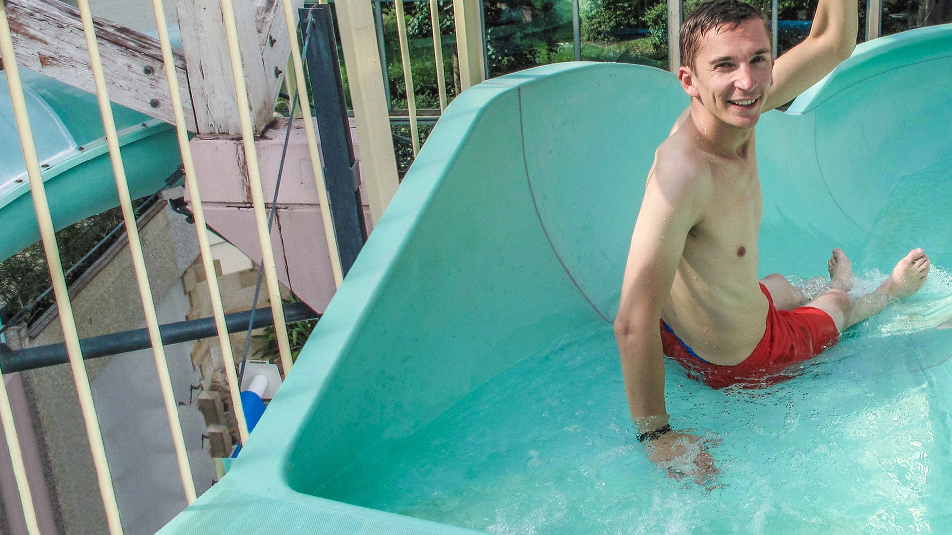 Moderator Eric Mayer sitzt startbereit in einer Wasserrutsche.