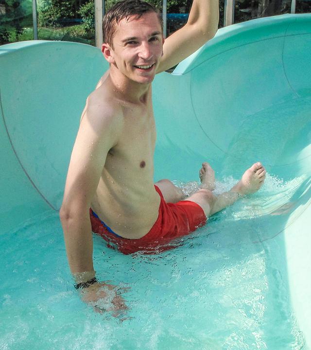 Moderator Eric Mayer sitzt startbereit in einer Wasserrutsche.