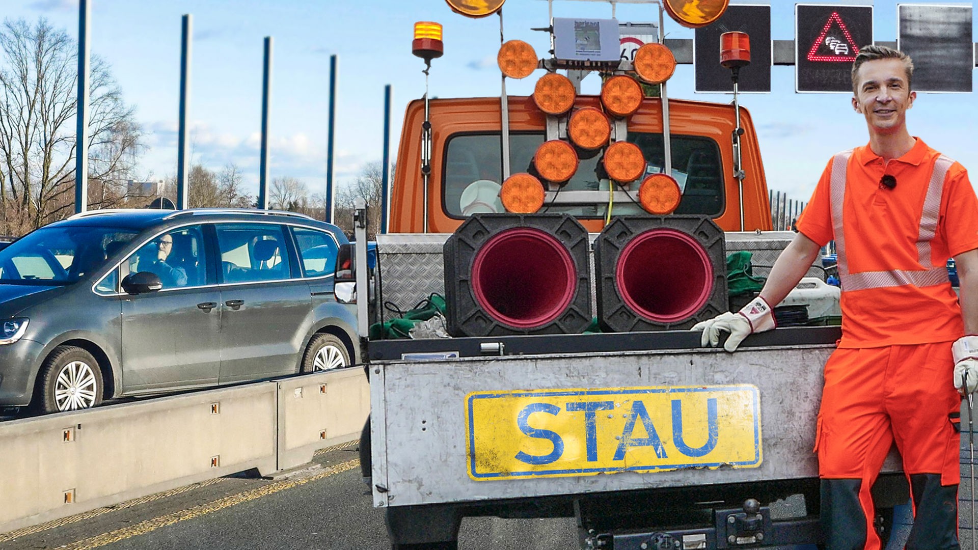 PUR+ Moderator Eric Mayer steht in orangefarbener Arbeitskleidung am Heck eines Baustellenfahrzeugs. Dieses hat auf der Ladefläche ein großes Warnkreuz mit Signallampen und ein Schild mit dem Schriftzug "Stau".