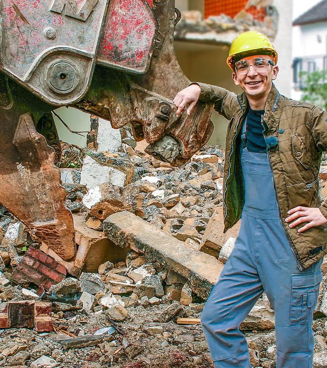 Eric vor einem abgerissenen Haus
