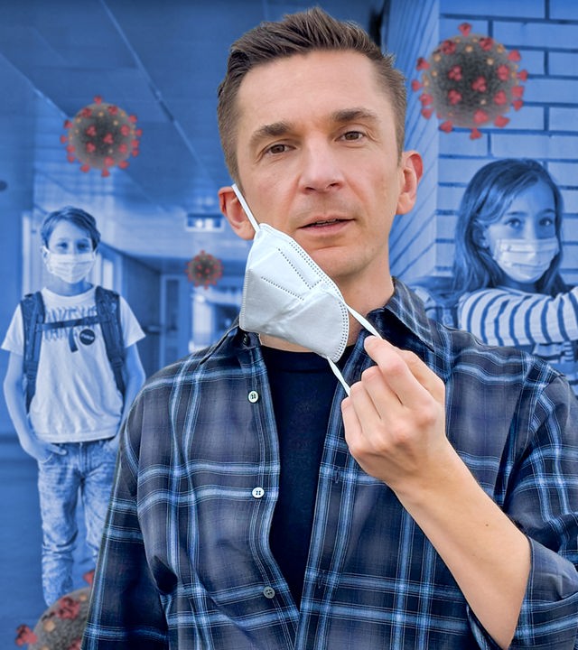 Eric steht im Vordergrund und zieht eine FFP2-Maske vom Gesicht. Im Hintergrund sieht man einen Schulflur und zwei Kinder mit Coronamaske.