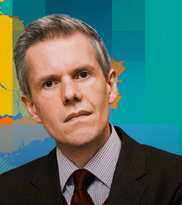 Militärökonom Markus Keupp ist vor einer Karte der Ukraine mit aktuellem Frontverlauf abgebildet.