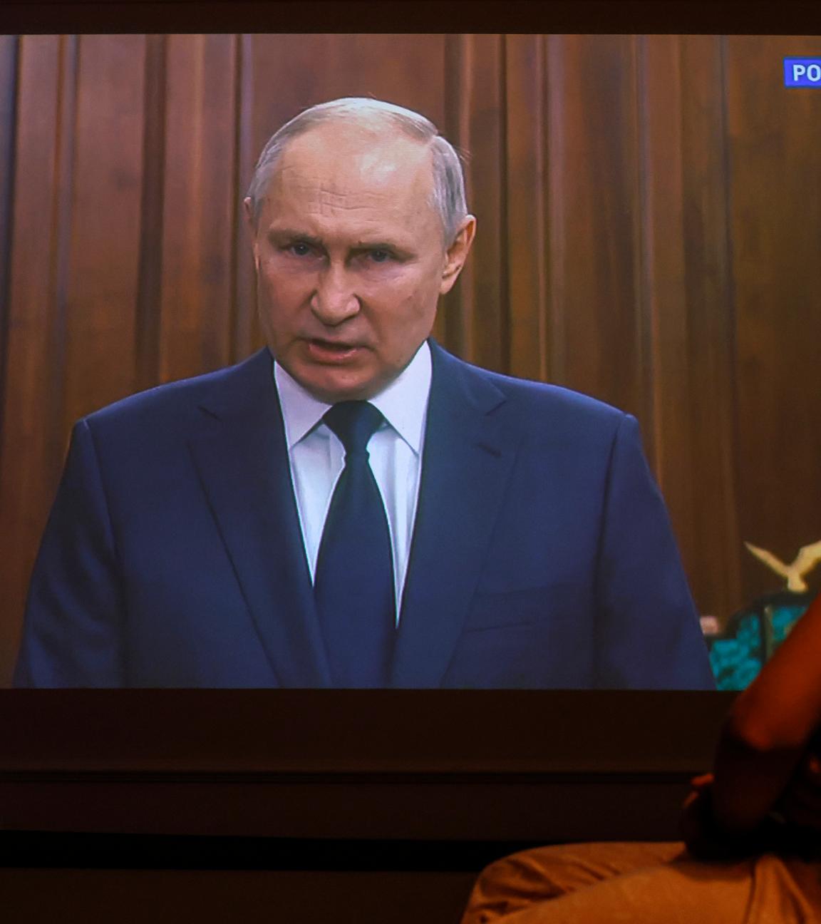 Russlands Präsident Putin spricht im Fernsehen, Menschen schauen zu