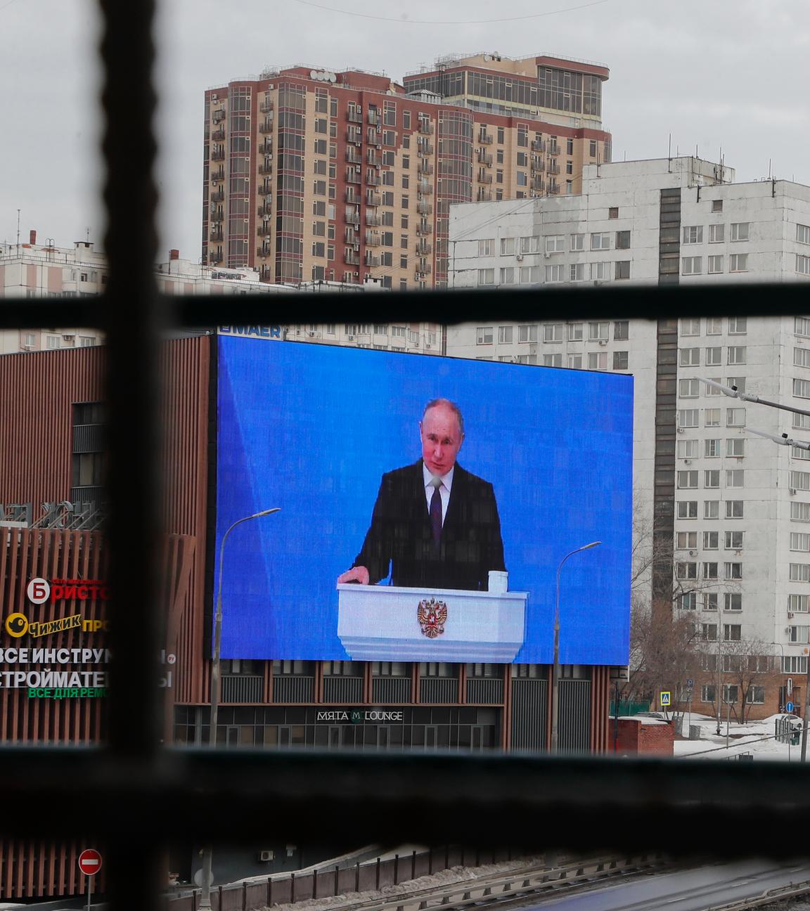 Ein Bildschrim an einem Gebäude, auf dem Bildschirm ist Waldimir Putin zu sehen.