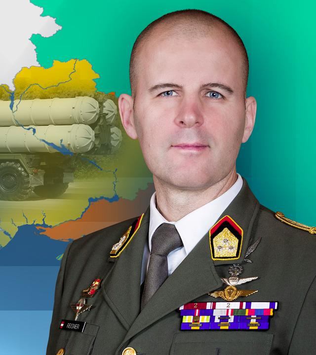 Oberst Reisner ist in seiner Uniform vor einer Karte der Ukraine zu sehen. Im Hintergrund sind Oreschnik-Raketen zu sehen.