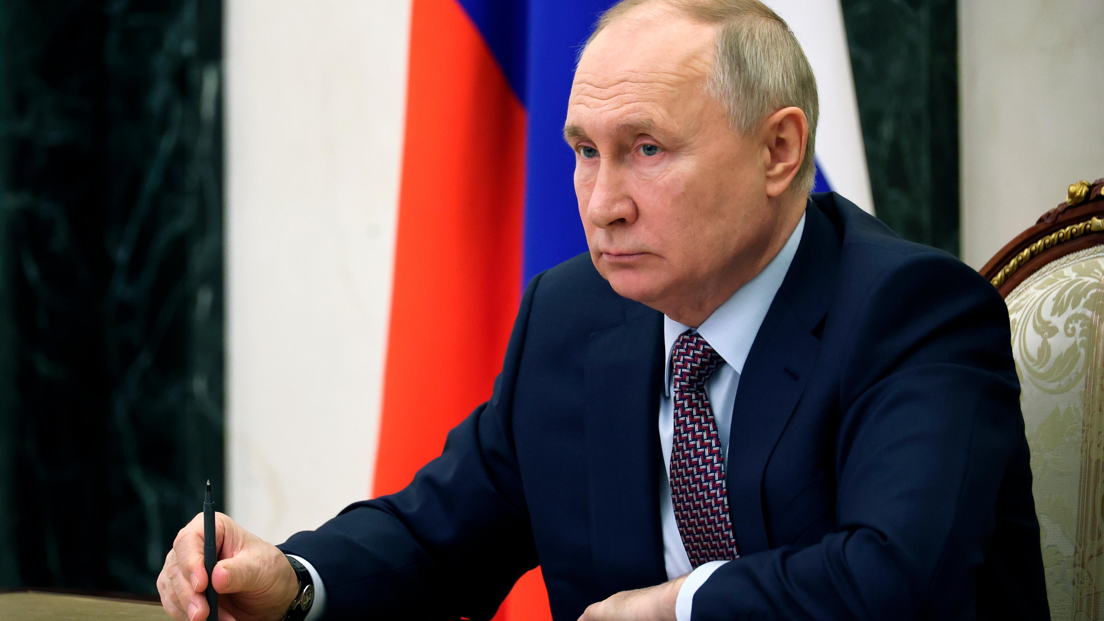 Russlands Präsident Putin sitzt an seinem Schreibtisch.