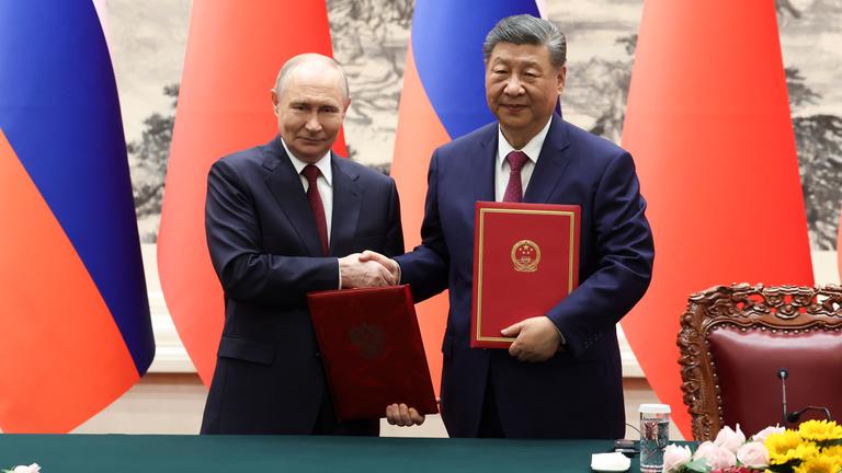 China, Peking: Der russische Präsident Wladimir Putin, links, und der chinesische Präsident Xi Jinping geben sich während einer Unterzeichnungszeremonie in der Großen Halle des Volkes die Hand