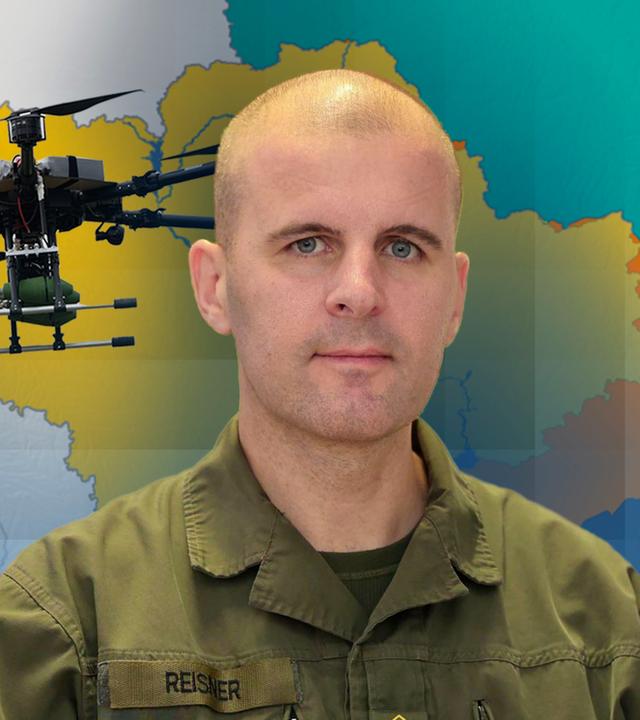 Oberst Markus Reisner vor einer Karte der Ukraine und einer fliegenden Drohne
