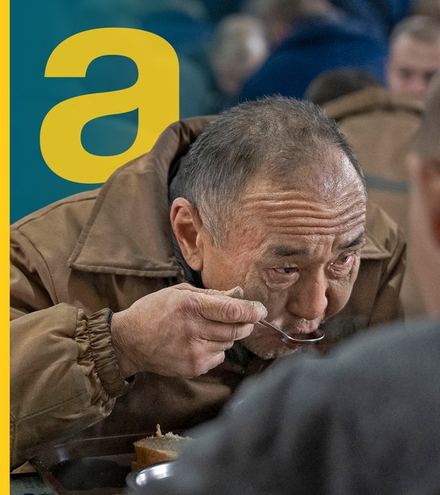 Ein Kriegsgefangener der gerade mit einem Löffel  Suppe isst.