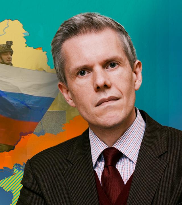 Dr. Marcus M. Keupp vor einer Karte der Ukraine mit Russischer Flagge im Hintergrund.