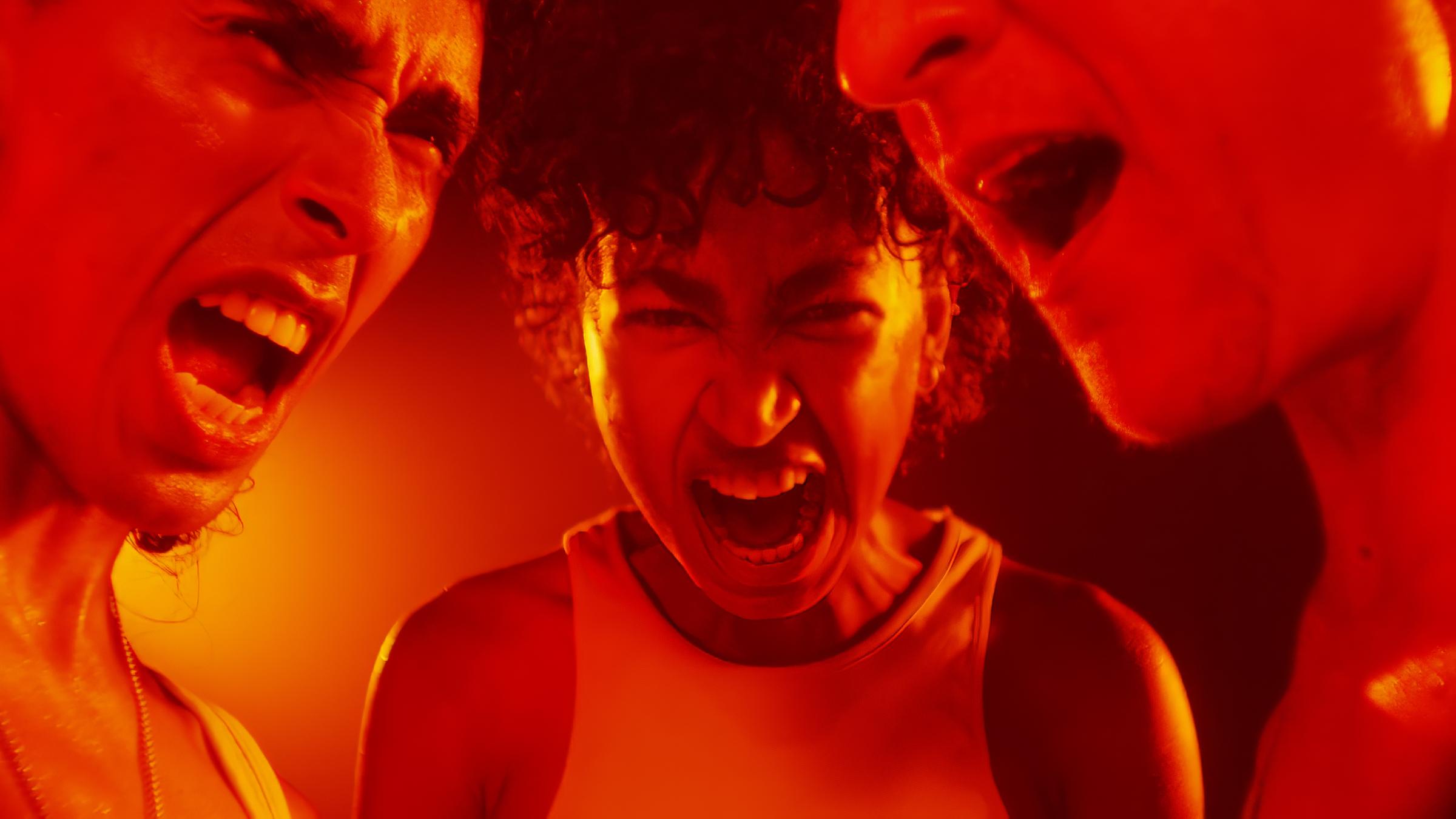 Nahaufnahme von drei Köpfen, die ihre Münder zum Schrei geöffnet haben.