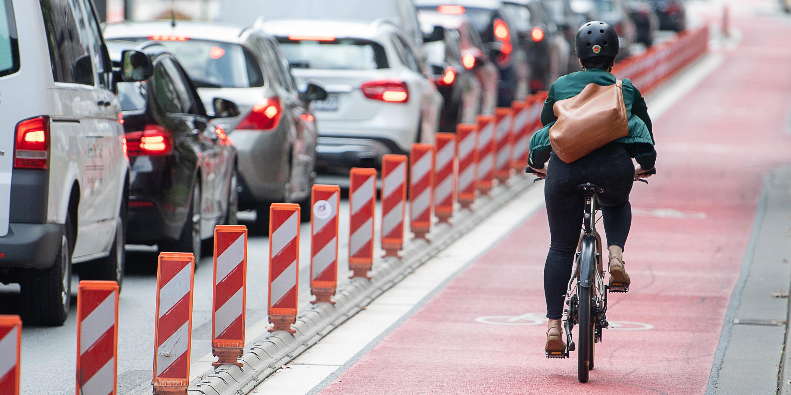 Hessen, Frankfurt/Main: Eine Fahrradfahrerin fährt auf einer Fahrradspur an einer Straße.
