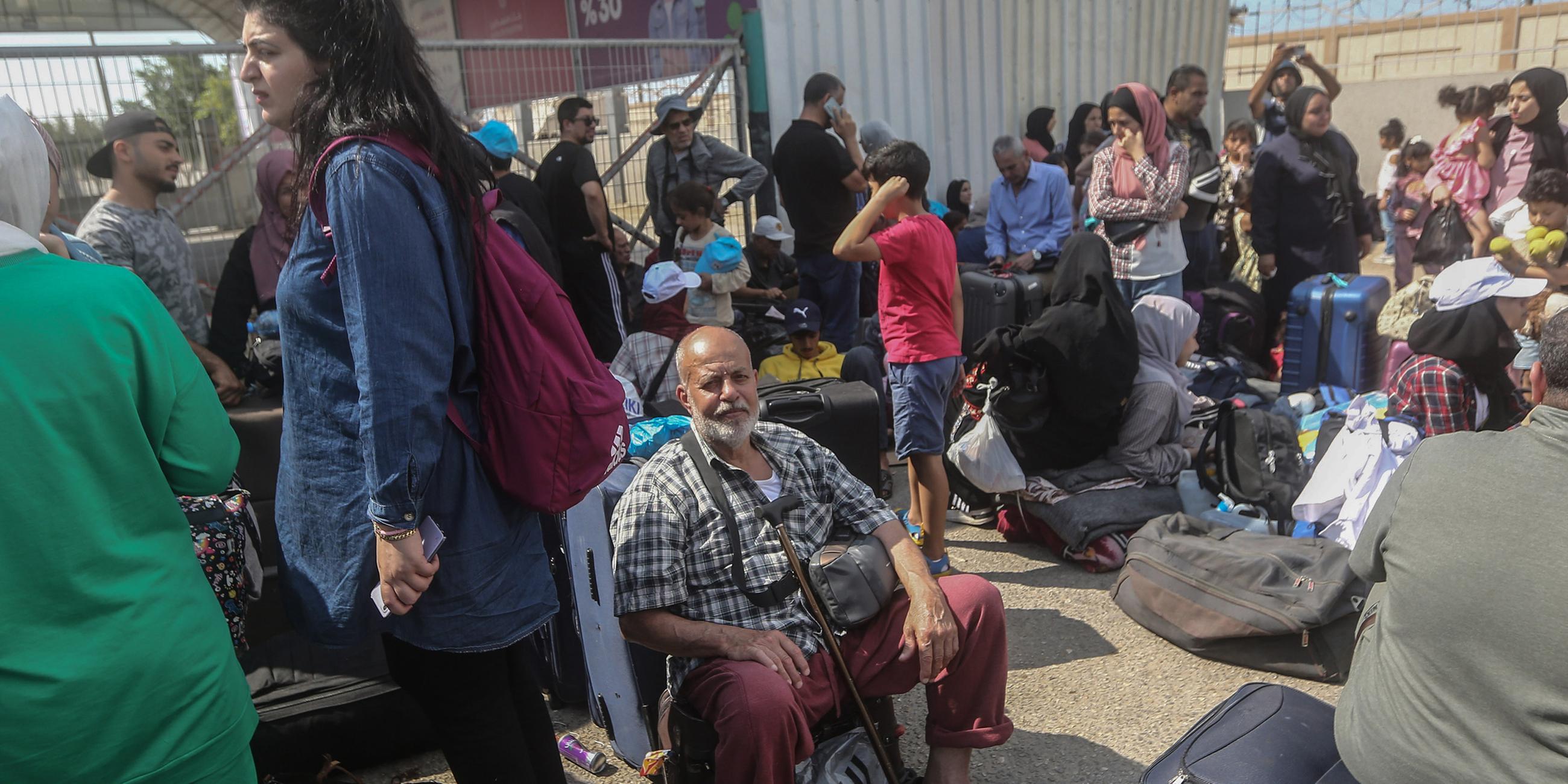 Palästinenser, einige mit ausländischen Pässen, warten am Grenzübergang Rafah auf Hilfe und eine mögliche Einreise nach Ägypten. 