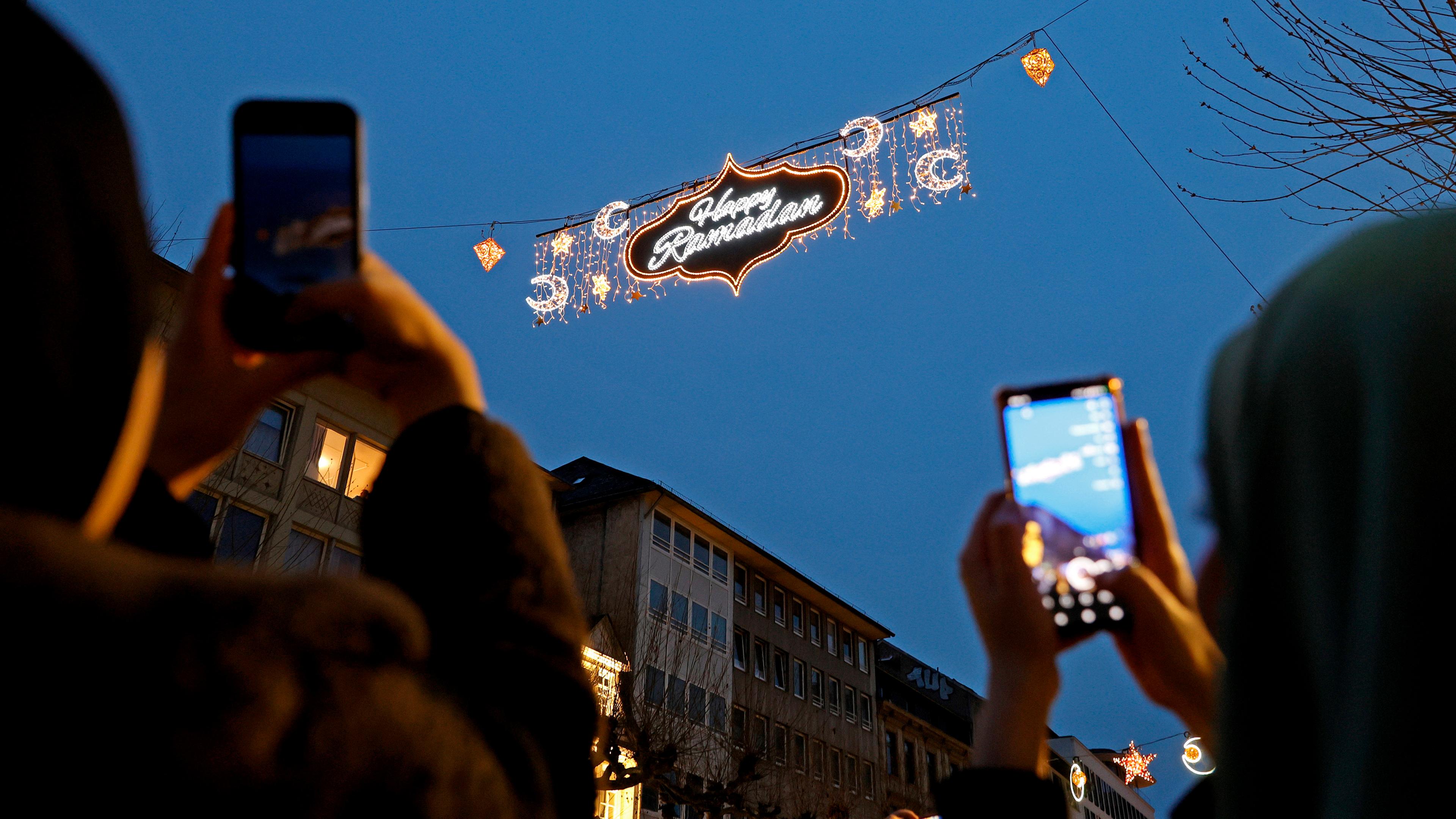 Ein beleuchtetes Schild mit der Aufschrift "Happy Ramadan" hängt über einer Einkaufsstraße in Frankfurt am Main, am 10.03.2024. 