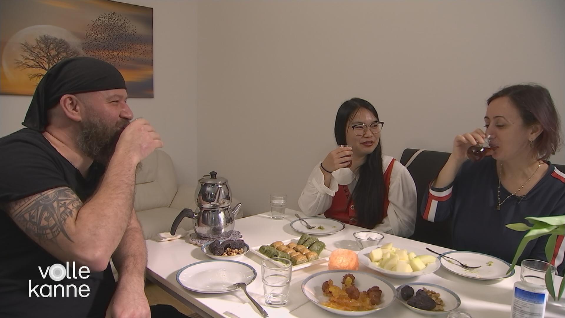 Drei Personen sitzen am Tisch und essen
