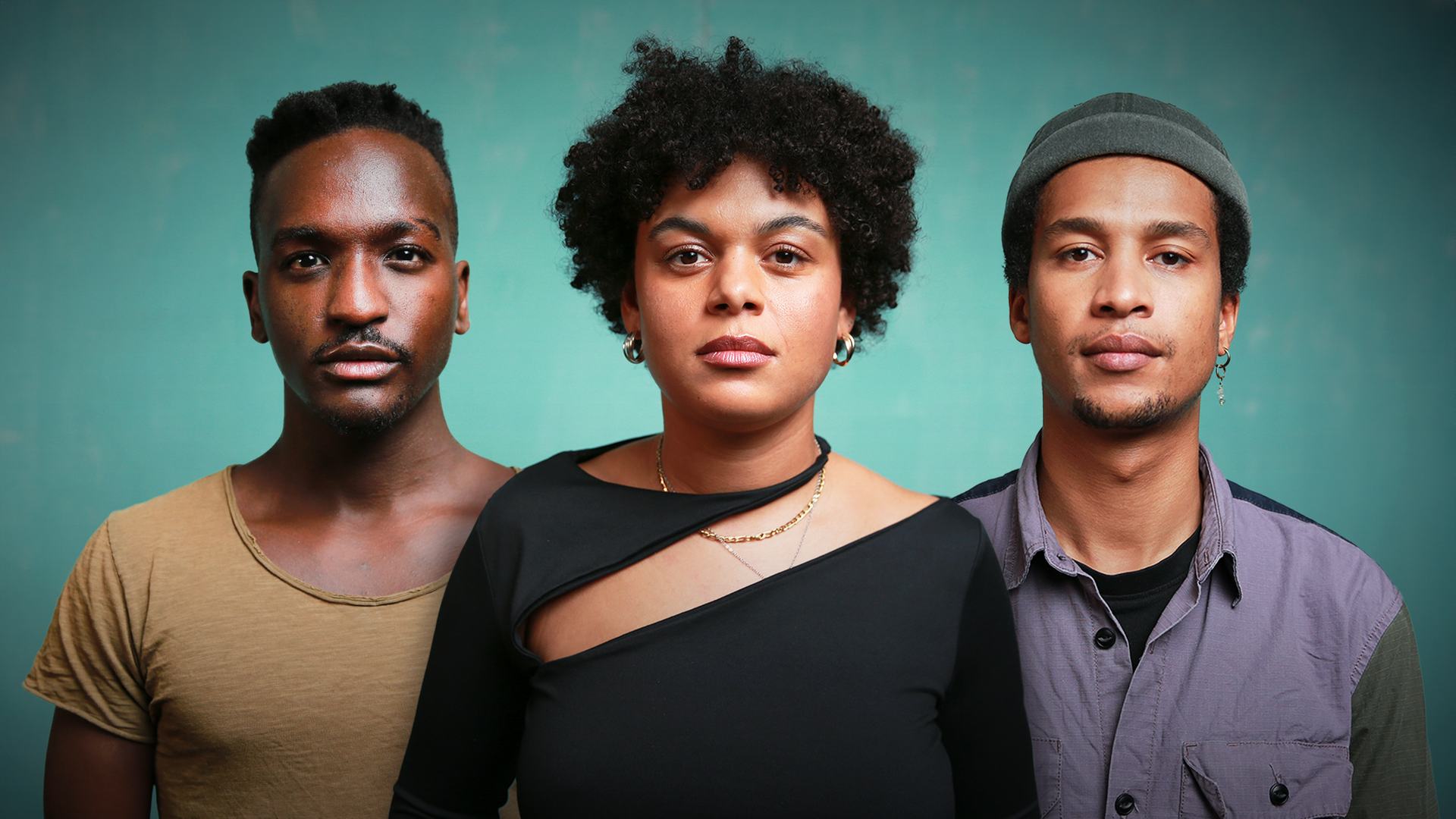 Zwei Männer und eine Frau stehen nebeneinander und blicken in die Kamera. Alle drei sind schwarz.