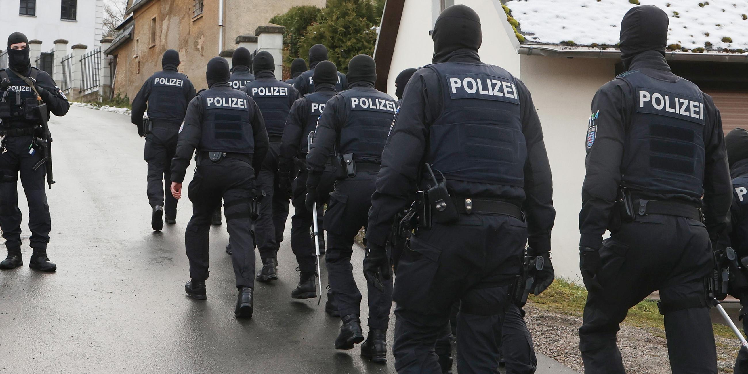 Einsatzkräfte der Polizei laufen zum Jagdschloss Waidmannsheil, während der Durchsuchung durch die Polizei.