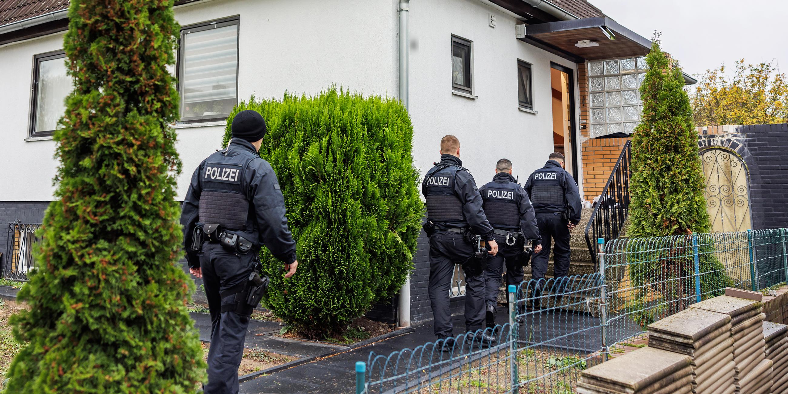 Polizeibeamte durchsuchen ein Haus in einer Wohnsiedlung in Niedersachsen am 23.11.2023.