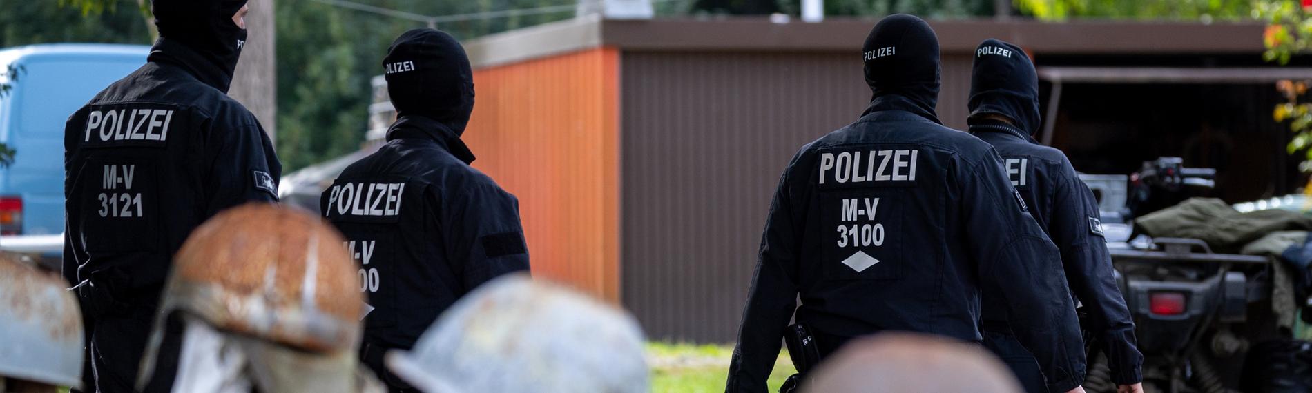 Polizisten gehen zur Sicherung von Beweismittel zum Haus des bundesweit bekannter Rechtsextremist Krüger auf dessen Gartenzaun rostige Stahlhelme hängen. (19.09.2023)