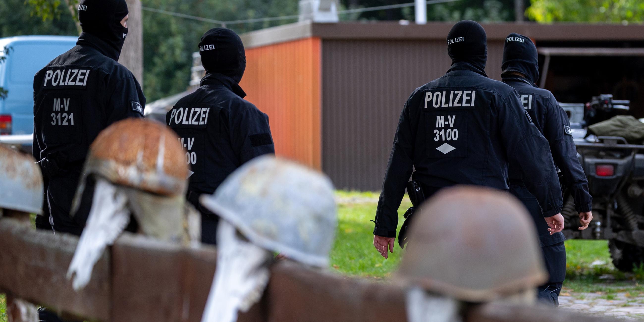 Polizisten gehen zur Sicherung von Beweismittel zum Haus des bundesweit bekannter Rechtsextremist Krüger auf dessen Gartenzaun rostige Stahlhelme hängen. (19.09.2023)