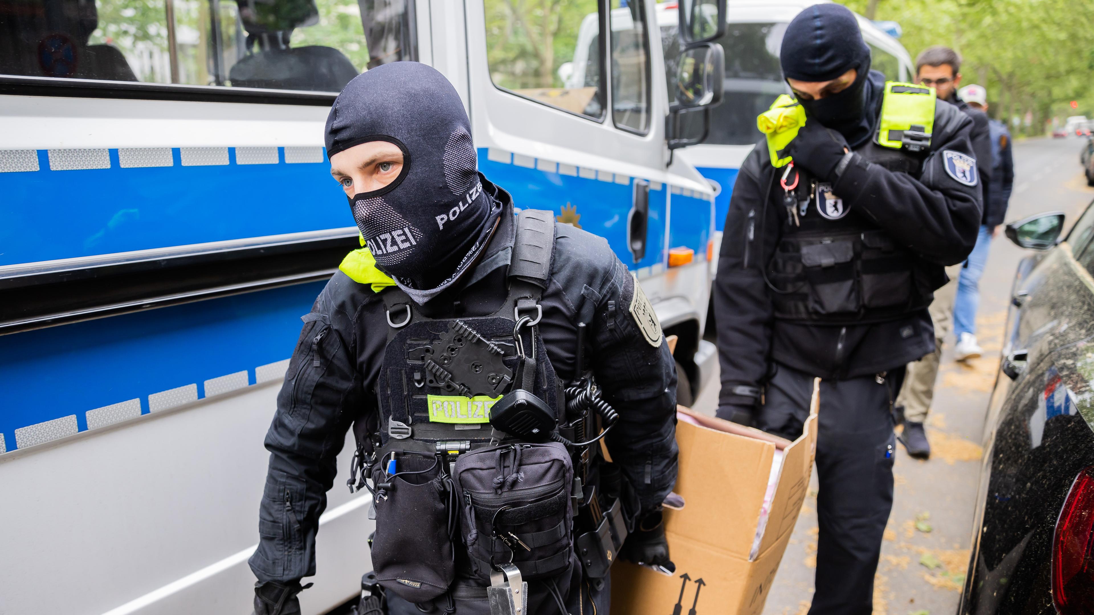 Polizisten tragen bei einer Hausdurchsuchung in Berlin-Kreuzberg einen Karton zu einem Fahrzeug, aufgenommen am 24.05.2023