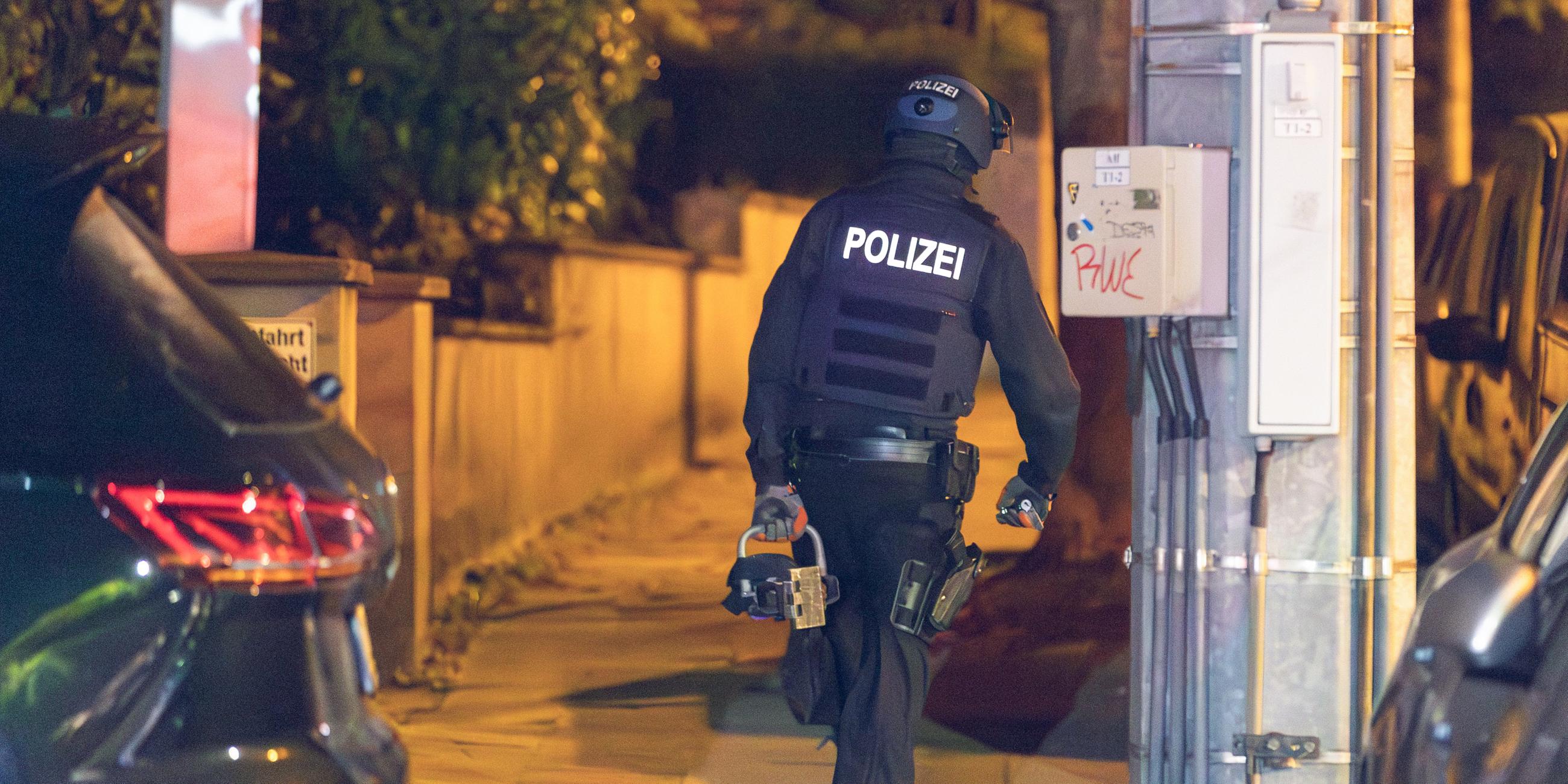  Ein Polizist trägt beim Einsatz einen hydraulischen Türöffner. 