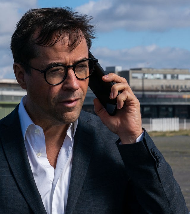 "Requiem für einen Freund": Joachim Vernau (Jan Josef Liefers) hält ein Telefon an sein linkes Ohr.