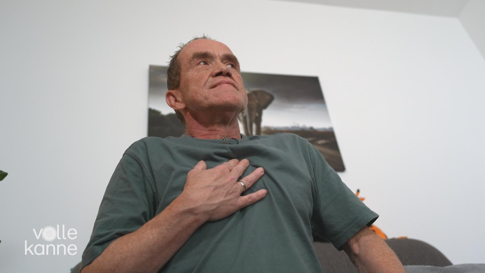 Mann hält sich Hand an die Brust