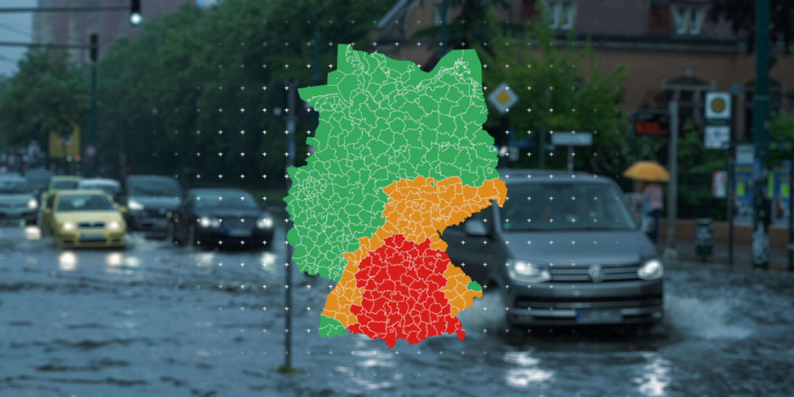 Autos fahren über eine überflutete Straße. Davor liegt eine Karte mit den aktuellen Regen-Warnungen des DWD