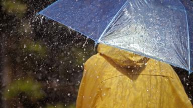 Gelber Regenmantel und Regenschirm