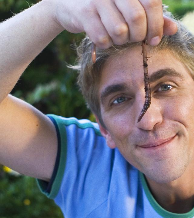 Fritz hält einen Regenwurm hoch