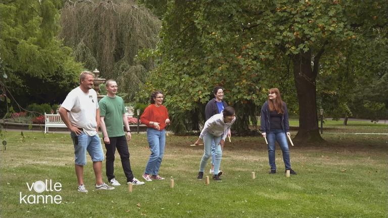 Reha für junge Krebspatienten: Junge Menschen zusammen auf einer Wiese bei einem Spiel.