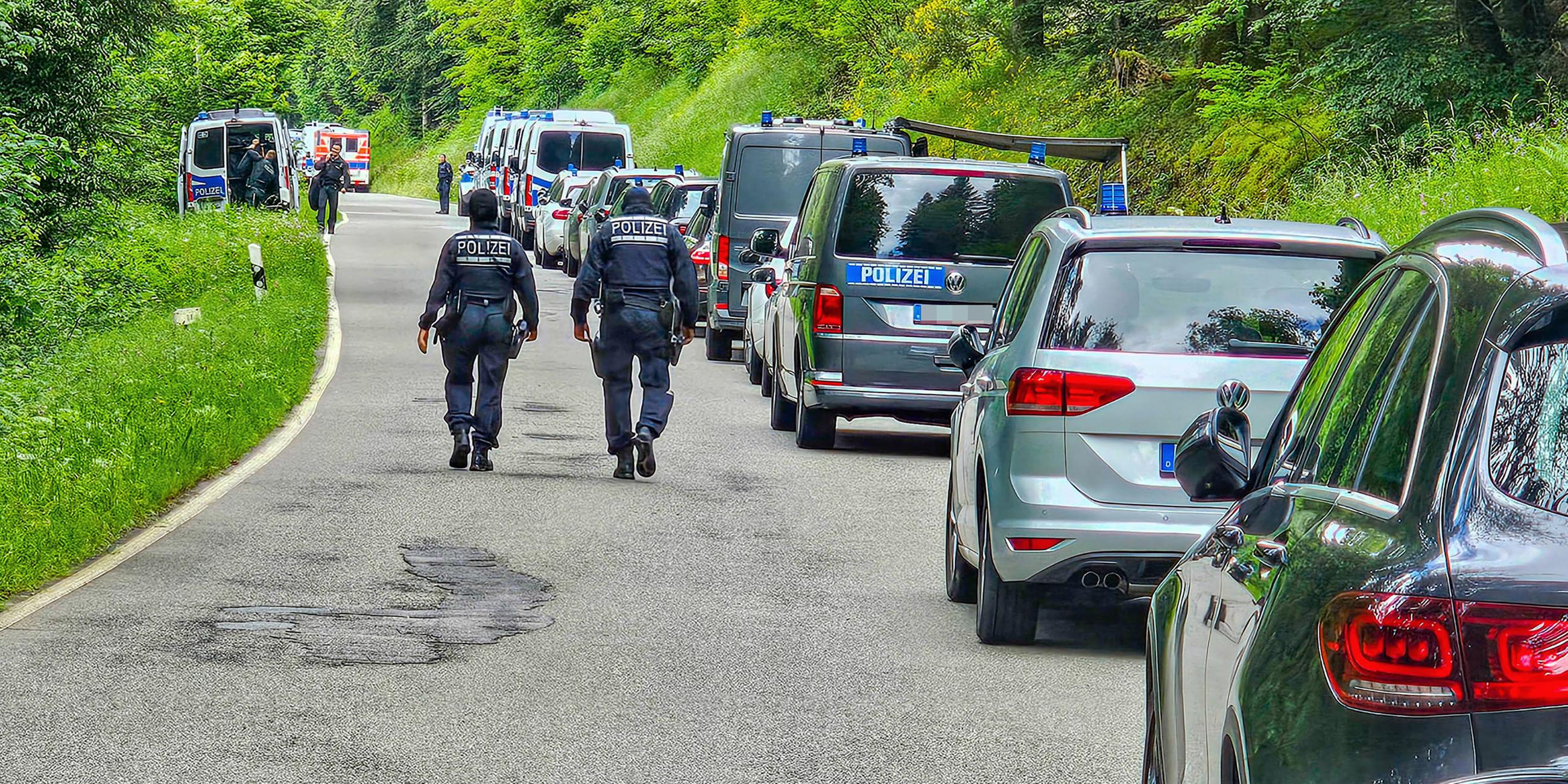 Polizisten sind bei einer Durchsuchung eines Grundstücks am Ortsrand von Althengstett in Baden-Württemberg im Einsatz.