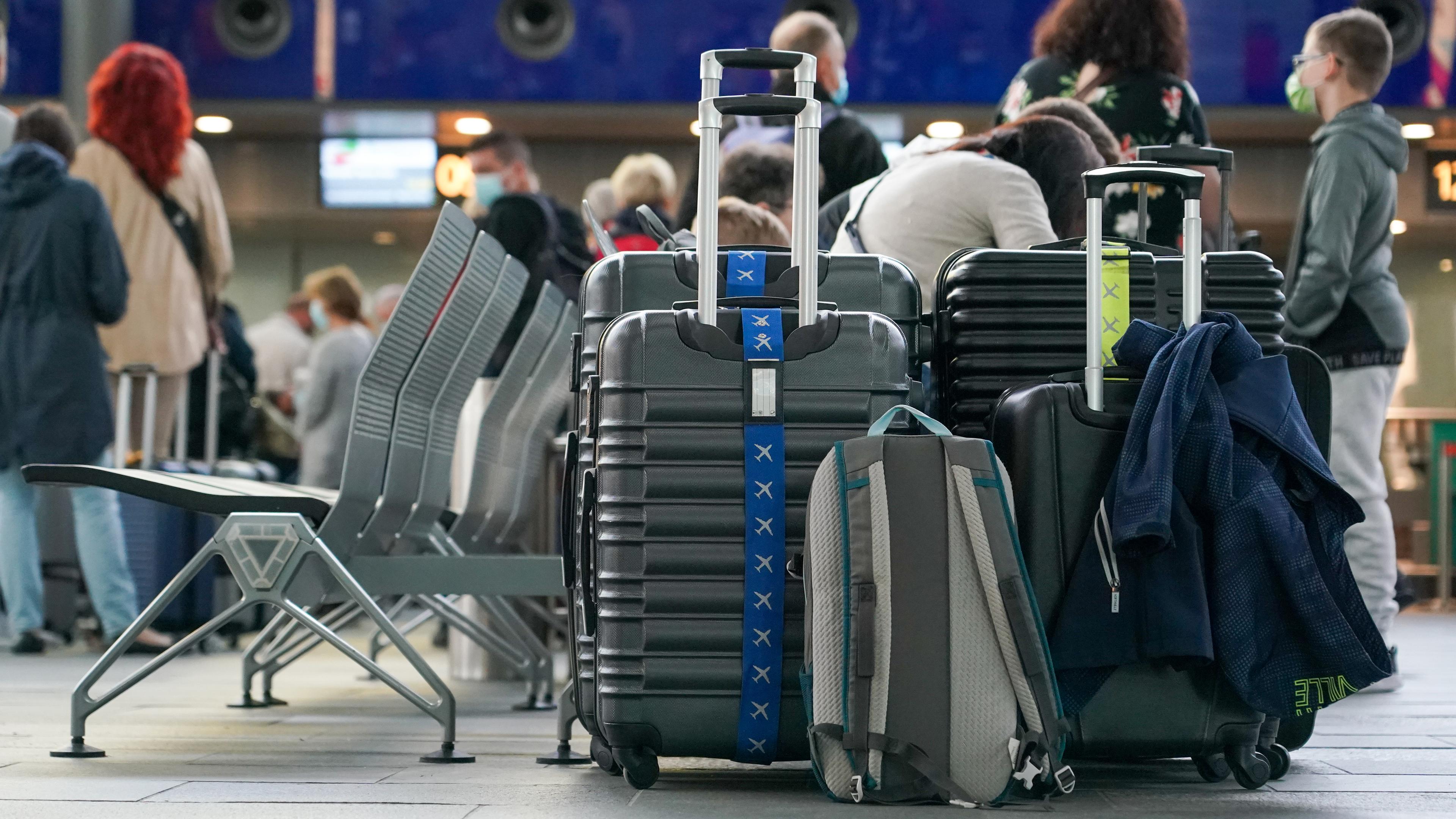 Sachsen, Schkeuditz: Reisende warten mit Gepäck am Check-in am Flughafen Leipzig/Halle.