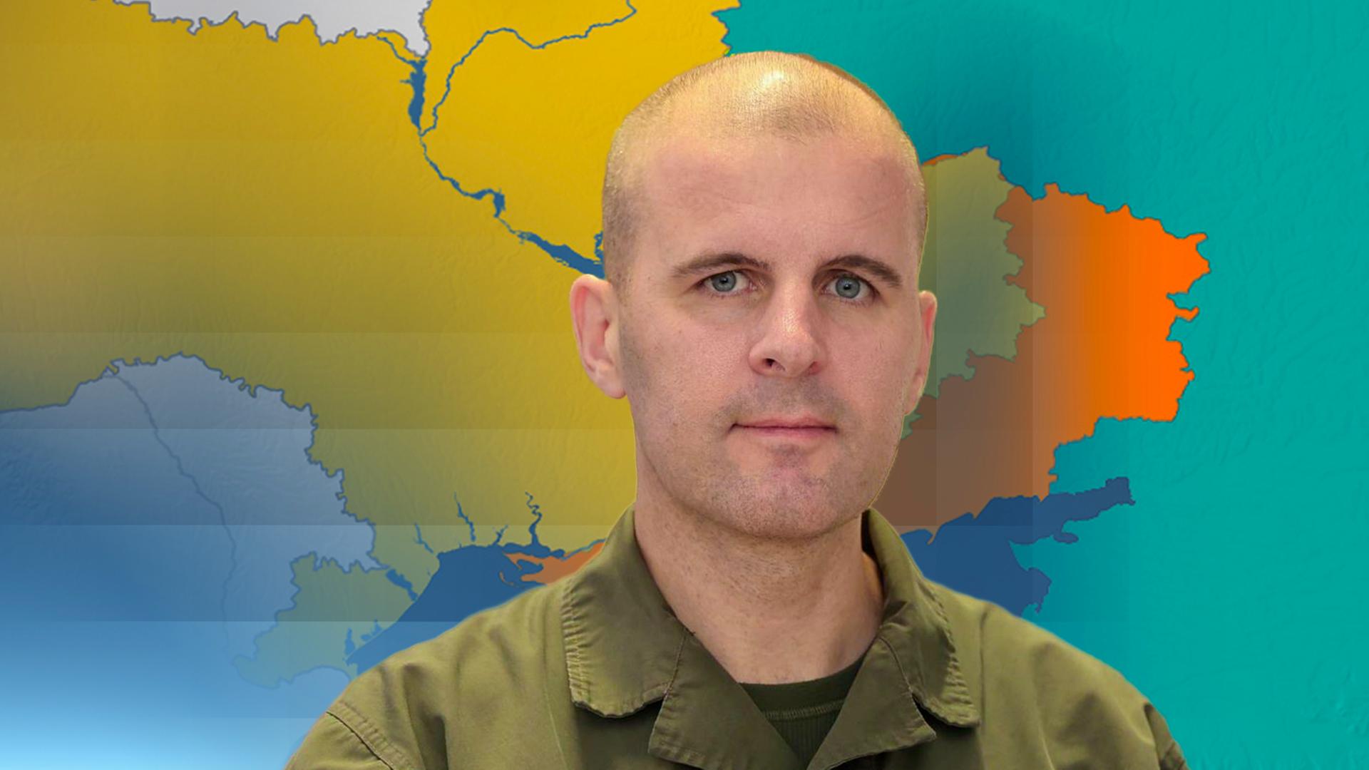 Oberst Markus Reisner, im Hintergrund eine Landkarte der Ukraine