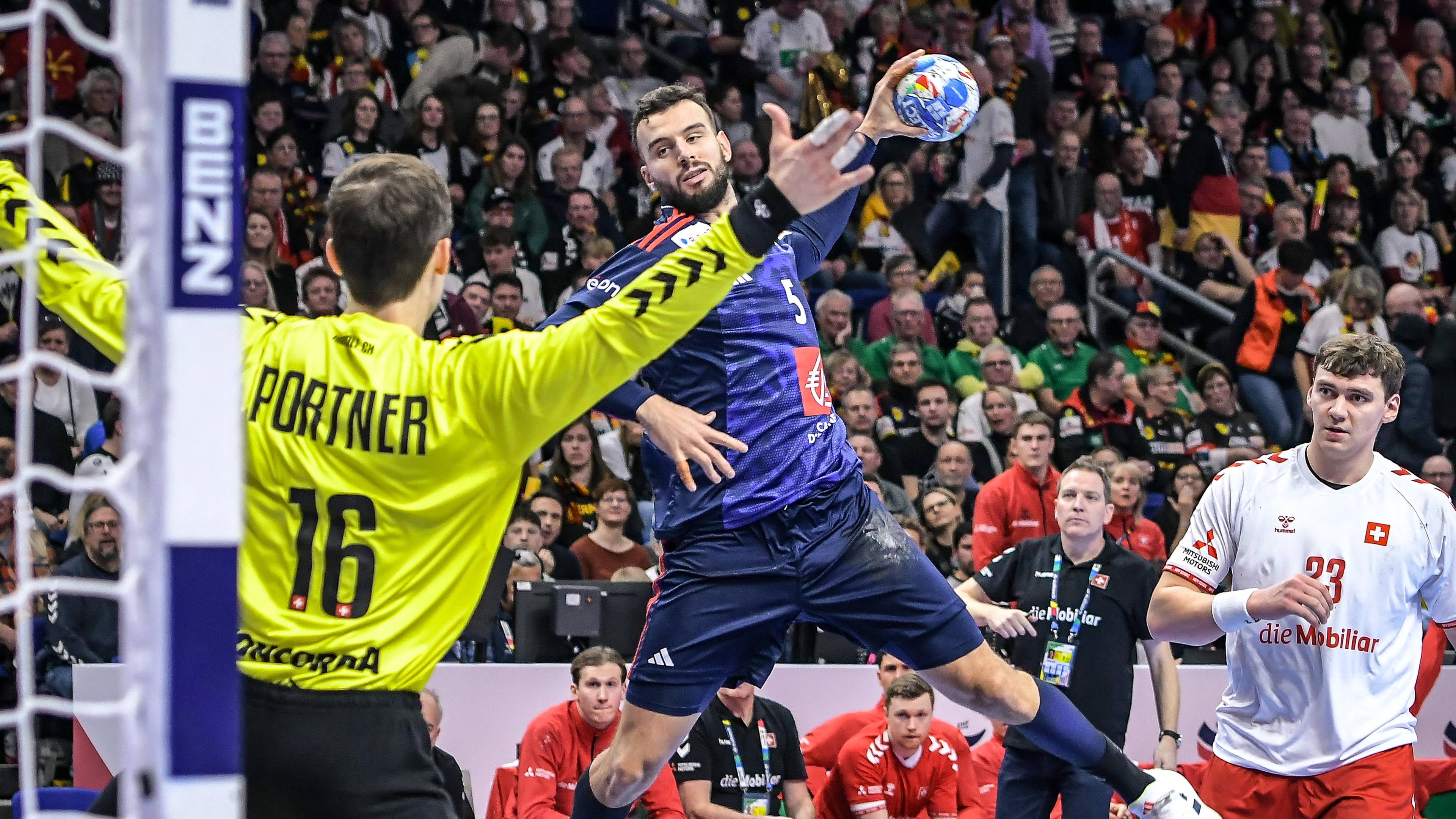 Handball-EM 2024, Schweiz - Frankreich am 14.01.2024: Nikola Portner versucht, einen Wurf von Nedim Remili (Frankreich) zu halten