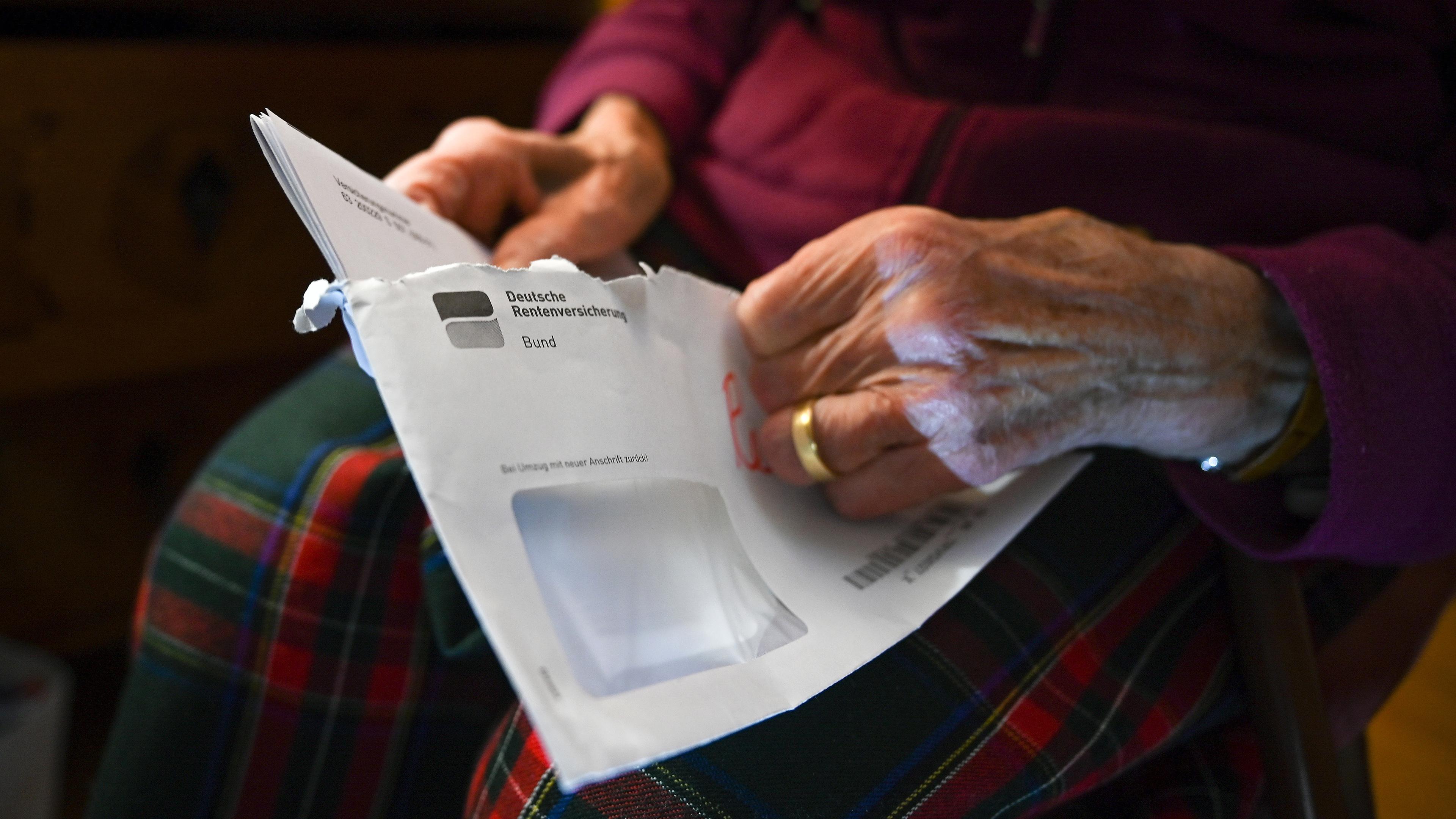 Eine Seniorin hält ihren Rentenbescheid in der Hand