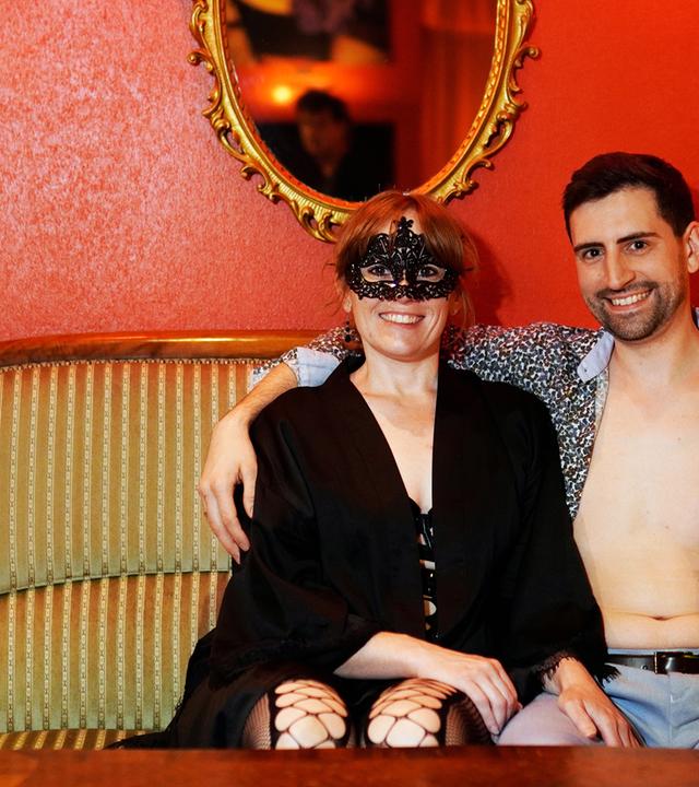 Eine maskierte Frau und ein Mann auf einer Couch